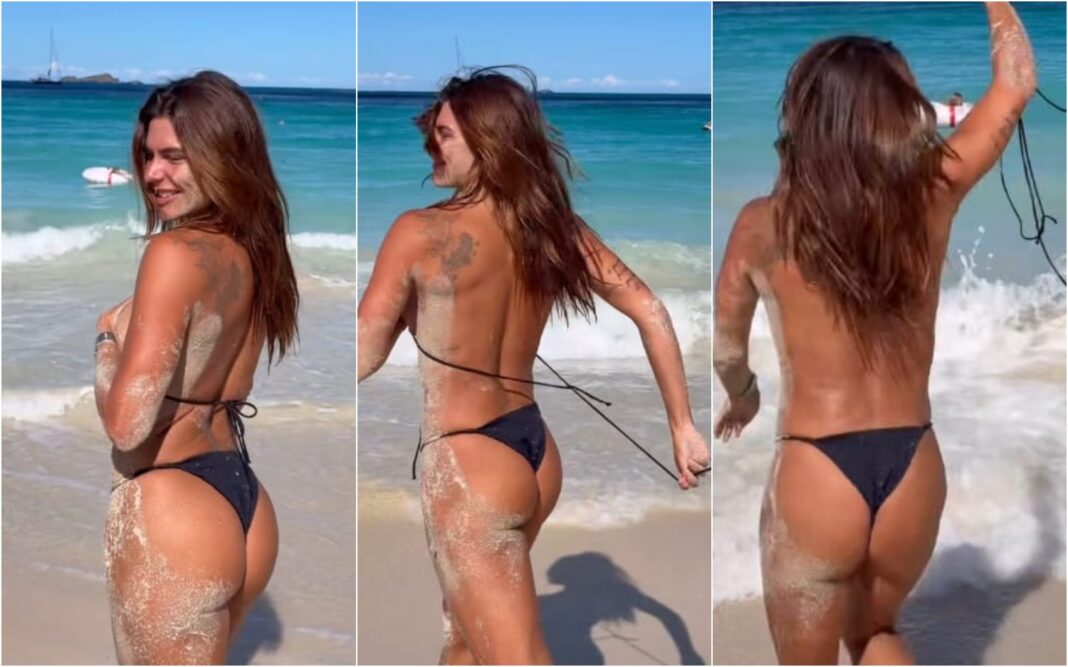 Mariana Goldfarb tira parte de cima biquíni para tomar banho de mar